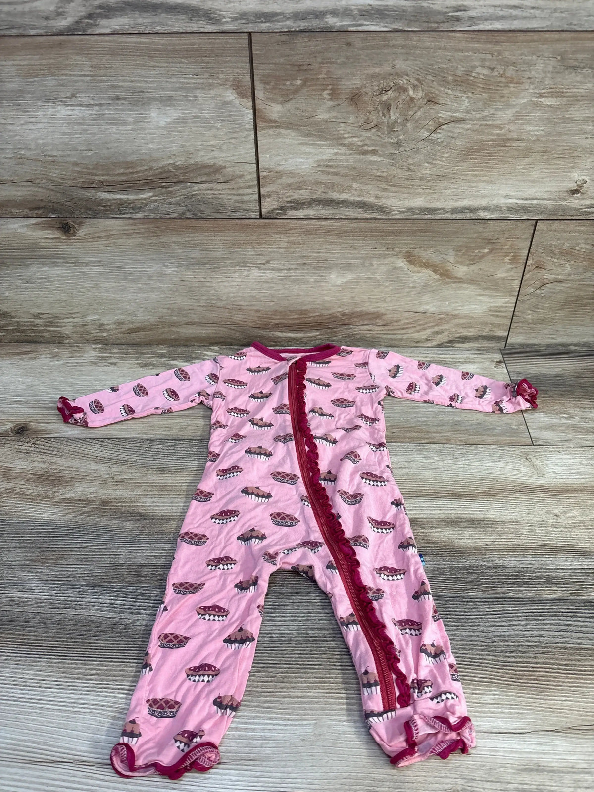 Front view of Kickee Pants bamboo muffin ruffle zip coverall in pink showing ruffle shoulders and front zipper on white background