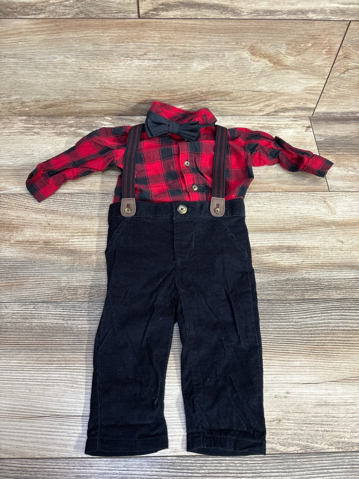Red plaid toddler shirt with black bow tie and black corduroy pants with suspenders