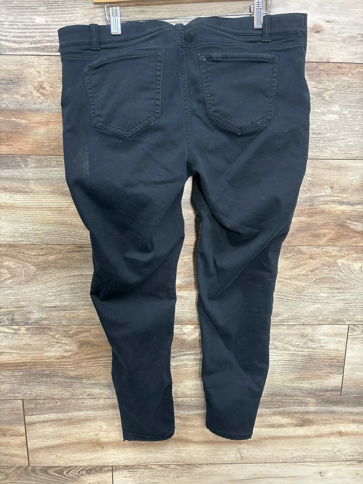 Back view of Isabel maternity utility jeggings in black, size large, showing back pockets and tapered legs on wooden floor