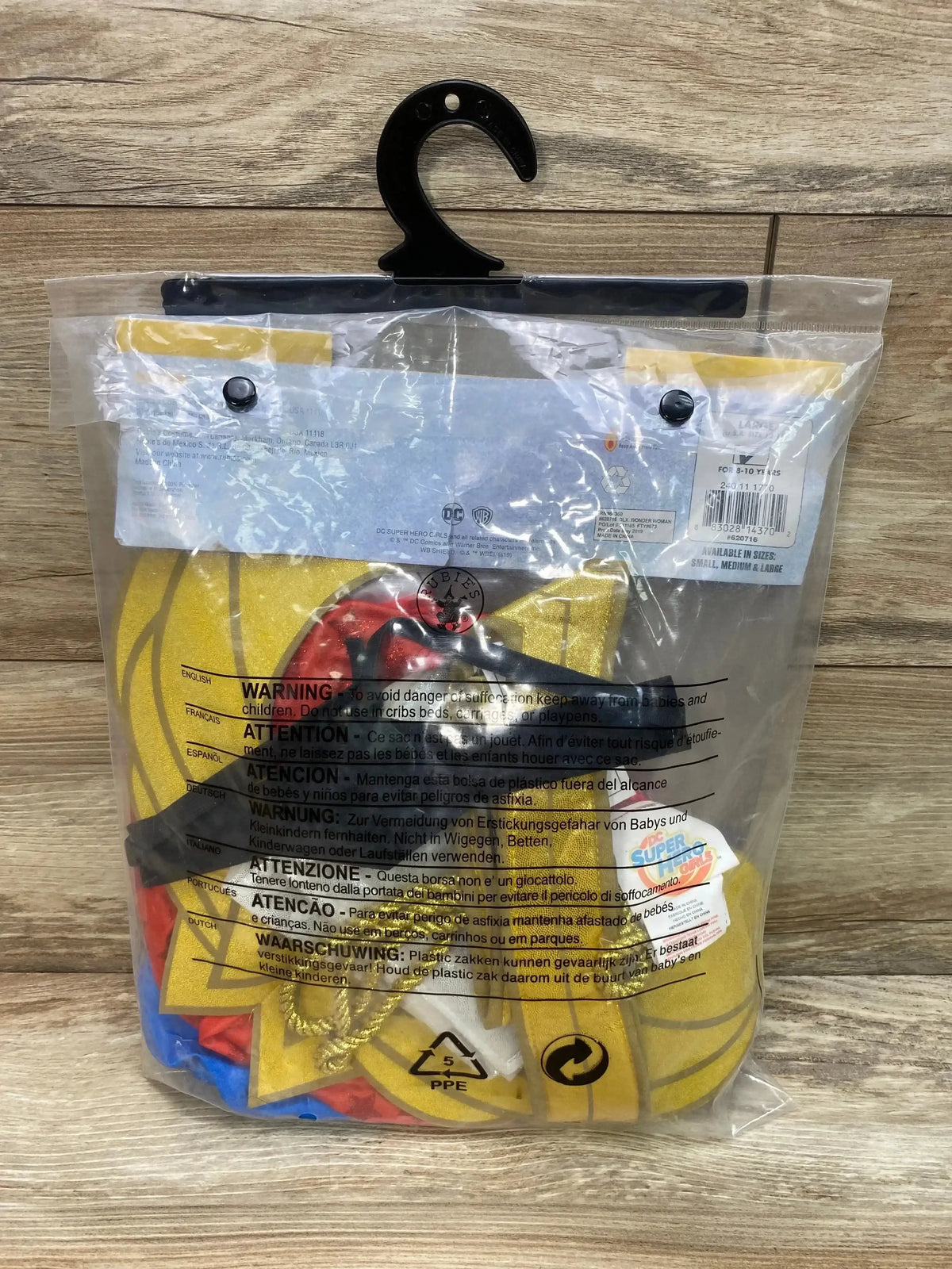 Front view of Rubie’s Wonder Woman costume in size 8-10 showcasing red, blue, and gold details in clear packaging on a wood surface