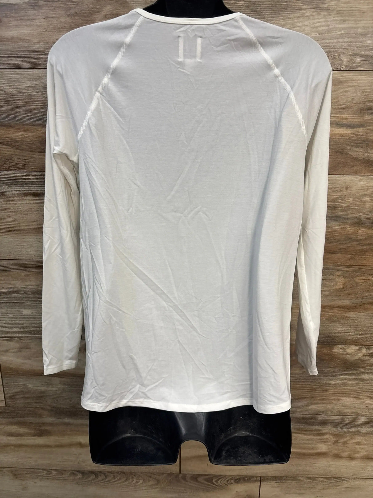 Back view of white Gap maternity long-sleeve Breathe shirt size small showing raglan sleeves and lightweight breathable fabric on wood background