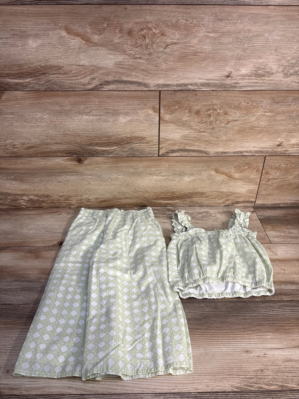 Front view of Janie & Jack two-piece checked set showcasing green ruffle-strap top and coordinating pants on wood background
