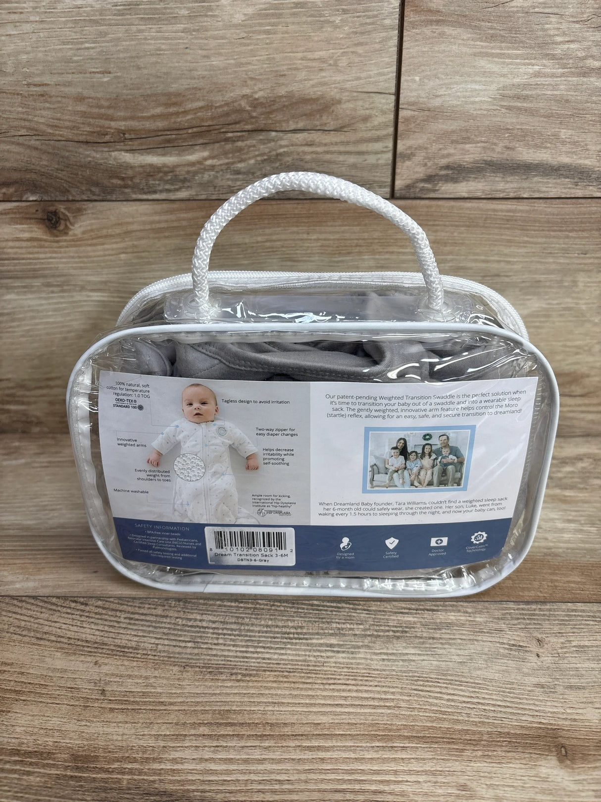 Baby sleep sack packaged in clear zippered bag on wood background, newborn essentials