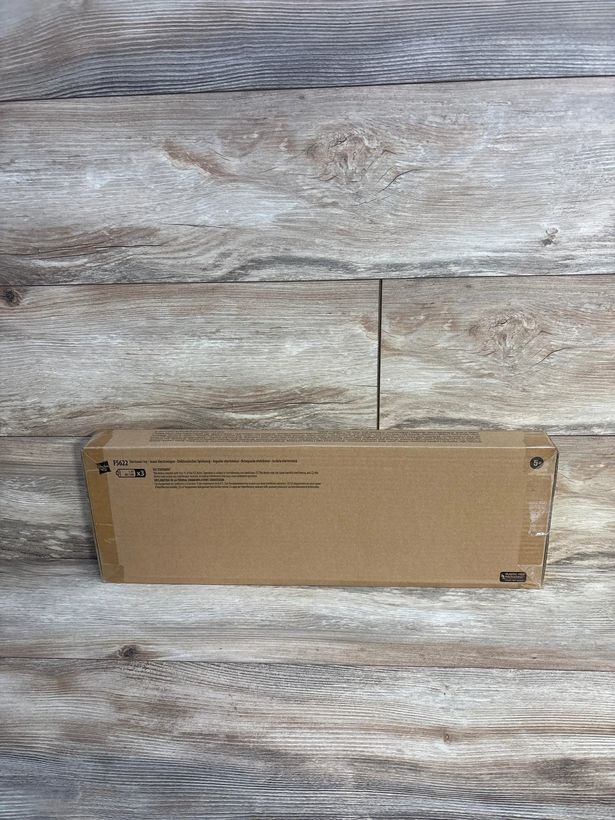 Front view of Spider-Man Spider-Punk Web Blast toy guitar in sealed box showcasing unopened packaging on wood floor
