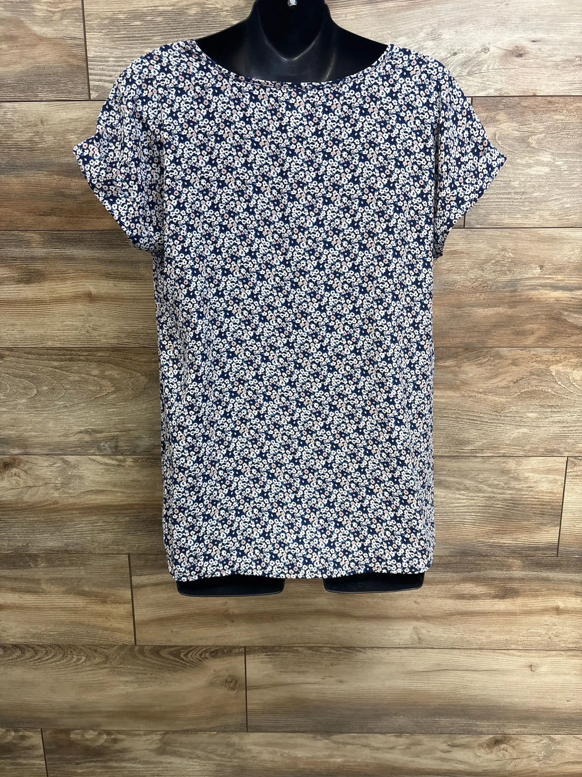 Front view of Motherhood Maternity floral v-neck shirt showcasing blue floral print and short sleeves on a black mannequin