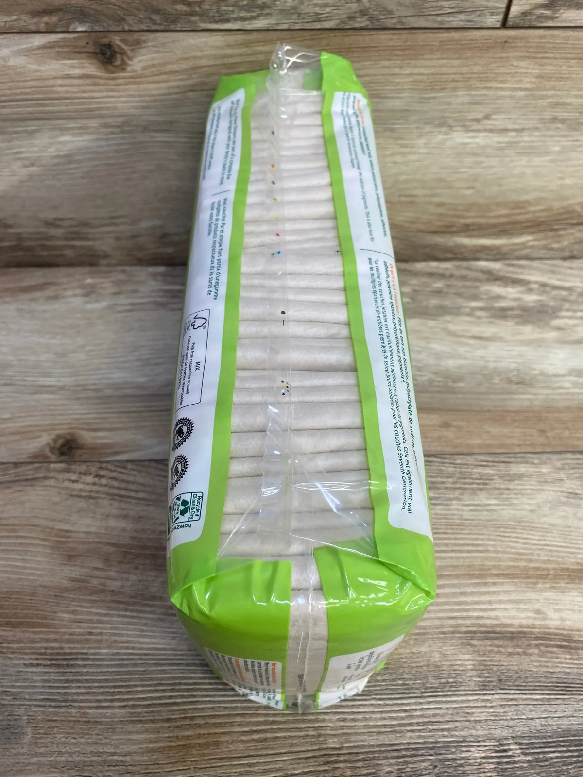 Top view of Seventh Generation Free & Clear size 1 diaper pack showing stacked diapers and 40 ct green pack on wood table