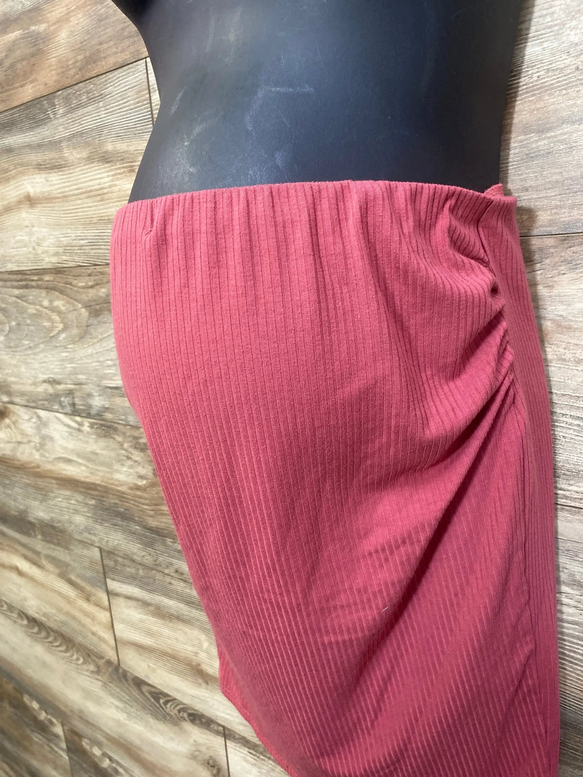 Overhead view of Shein red maternity ribbed skirt showcasing an elastic waistband and ruched side detail on a wood floor