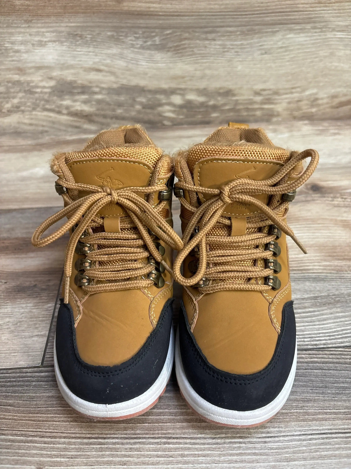 Front view of Beverly Hills Polo Flynn kids boot tan and black size 12C showing lace up front and padded collar on wood floor
