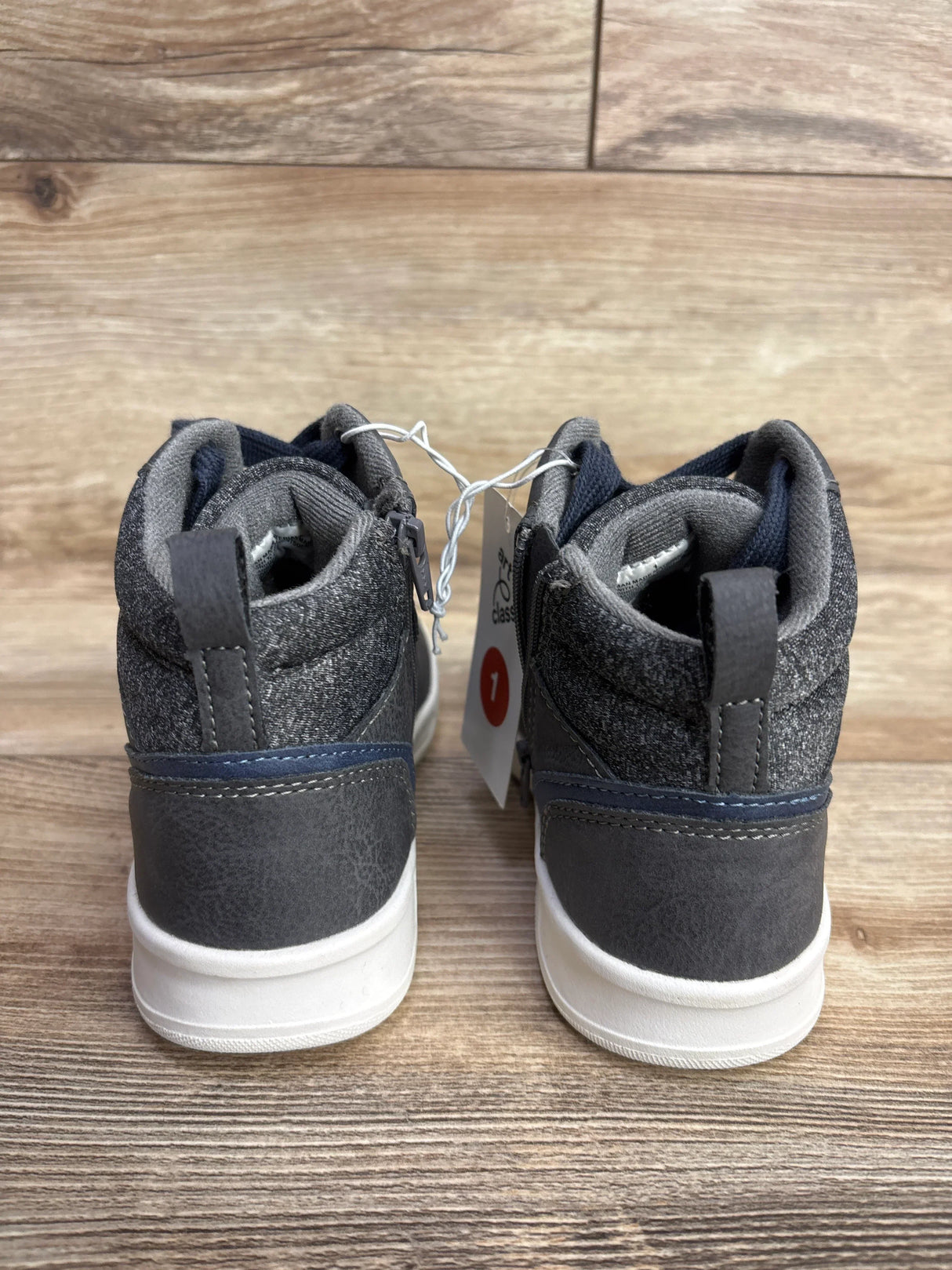 Back view of Art Class Geoff gray high top sneakers with navy trim white soles and hangtag on wood plank background