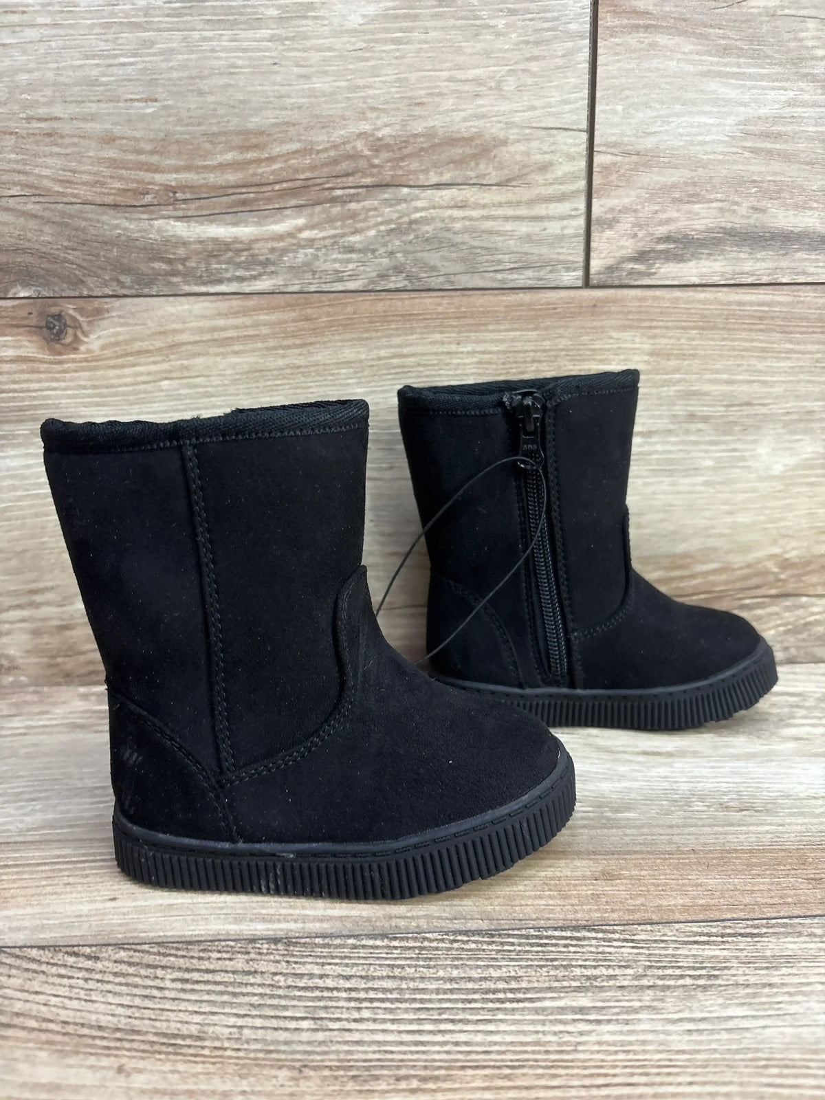 Black toddler boots with side zipper on wood floor, children's footwear resale