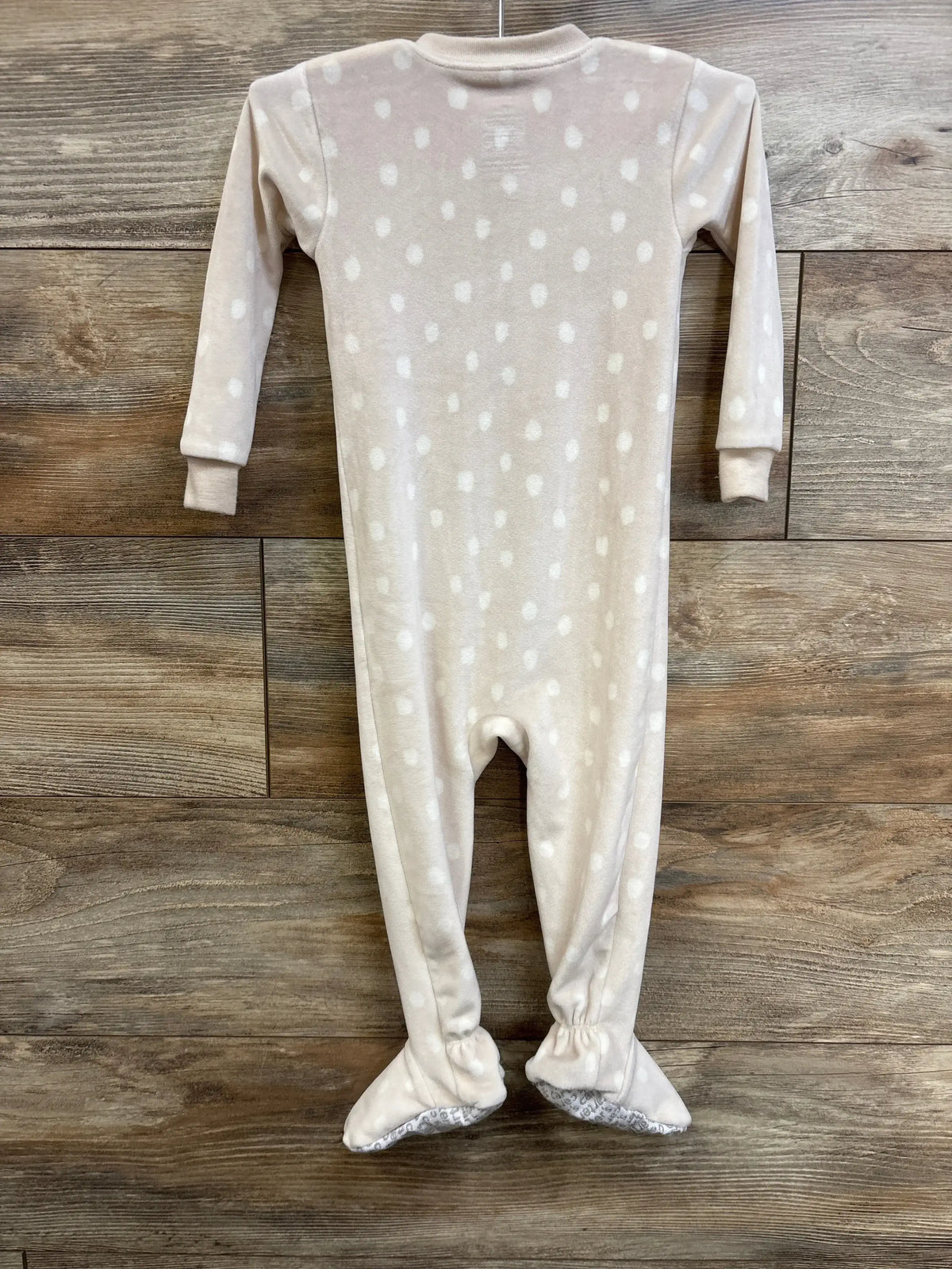Back view of ivory Carter’s blanket sleeper (18 months) showing white dot print and footed legs against wood background