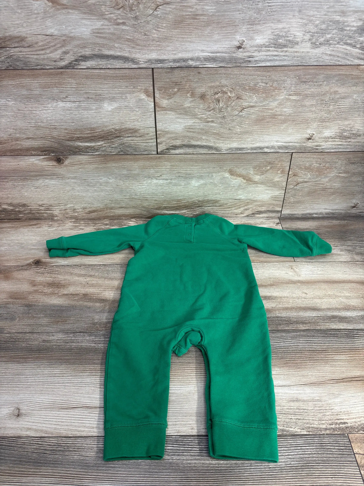 Green long sleeve baby romper laying flat on wooden surface