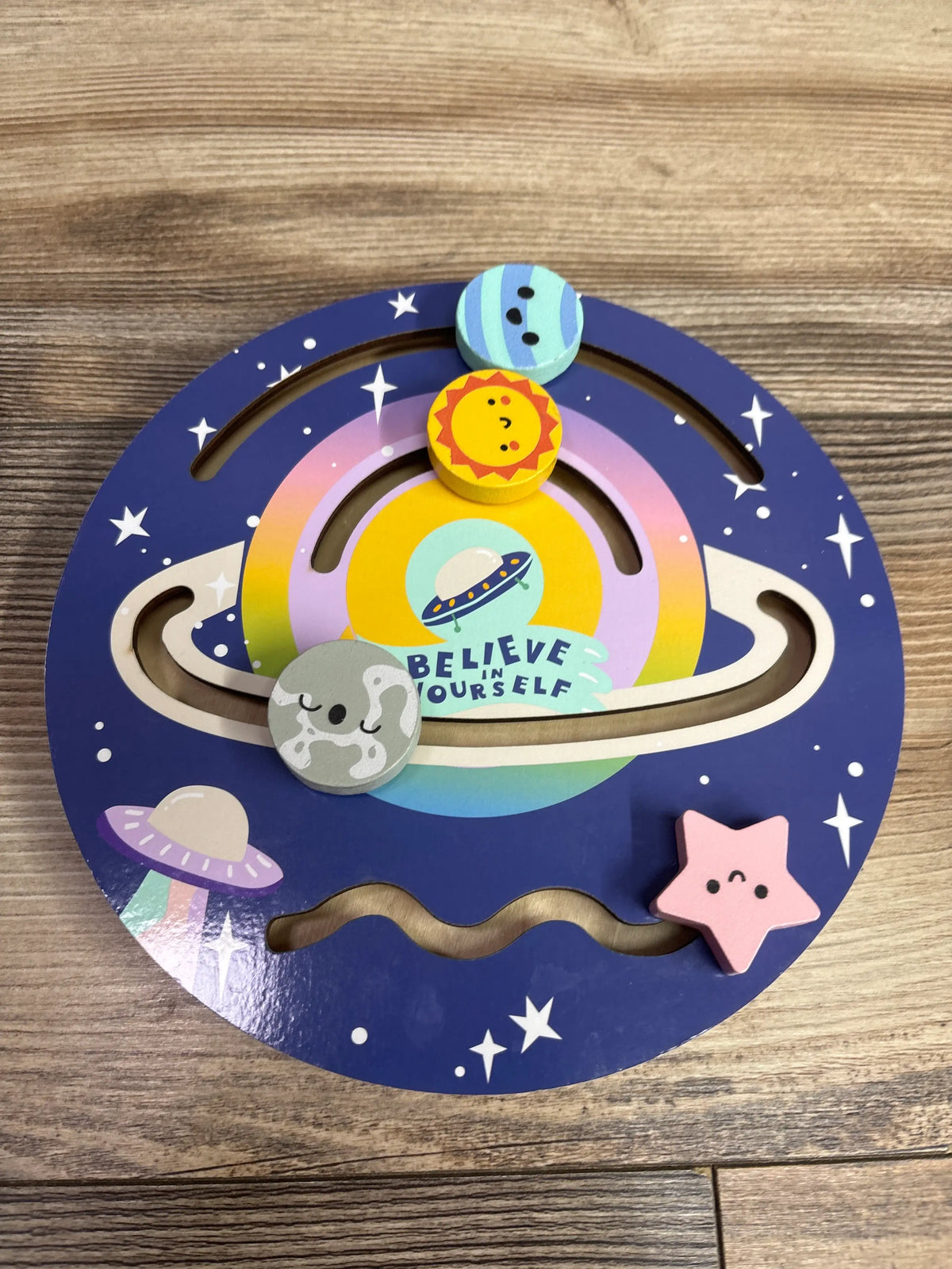 Top view of Bullseye’s Playground Wooden Sliding Maze Solar System showcasing planet pieces and Believe Yourself message