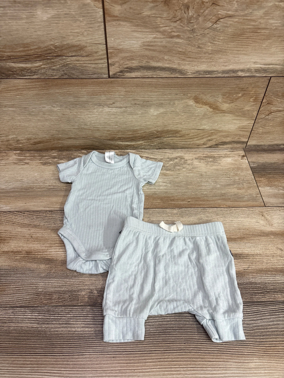 Flat lay of Modern Moments 2pc viscose bodysuit and pants set showcasing ribbed texture on wood flooring