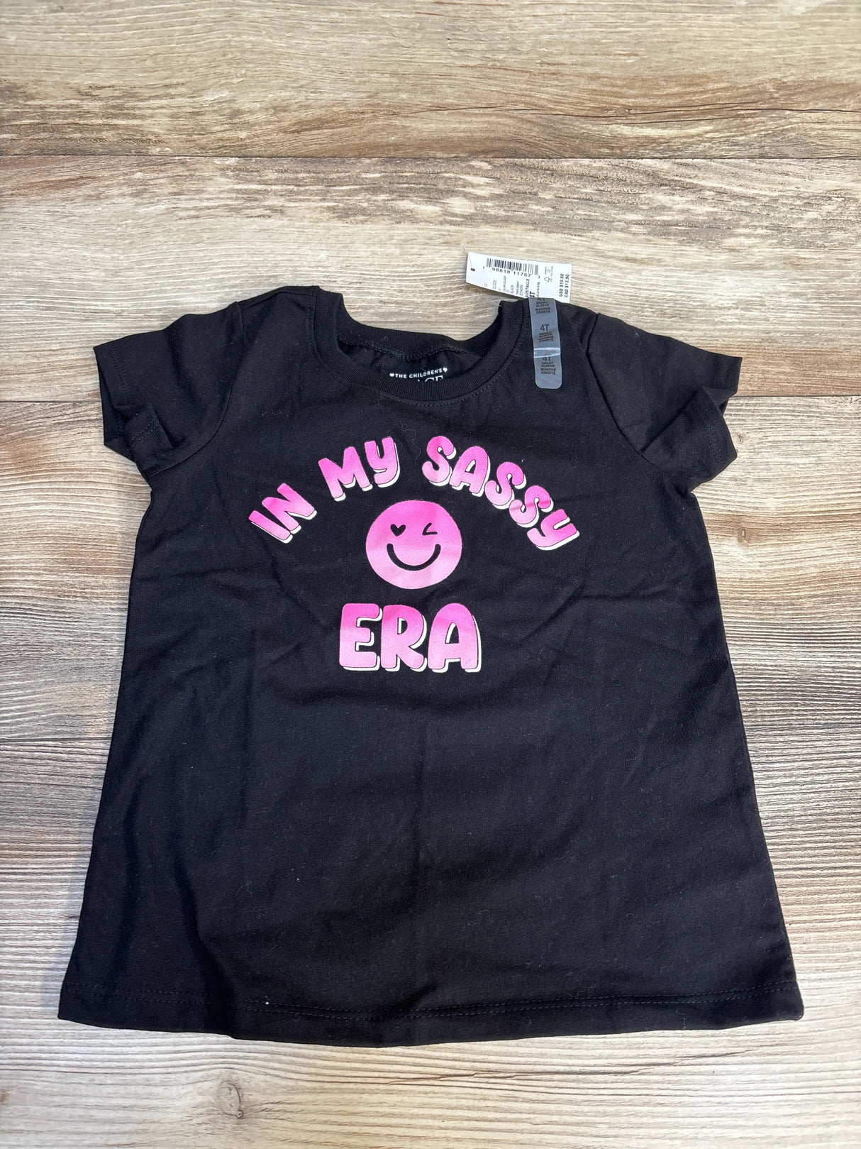 Black kids t-shirt with pink 'In My Sass Era' graphic and smiley face, size 4T, on wood floor