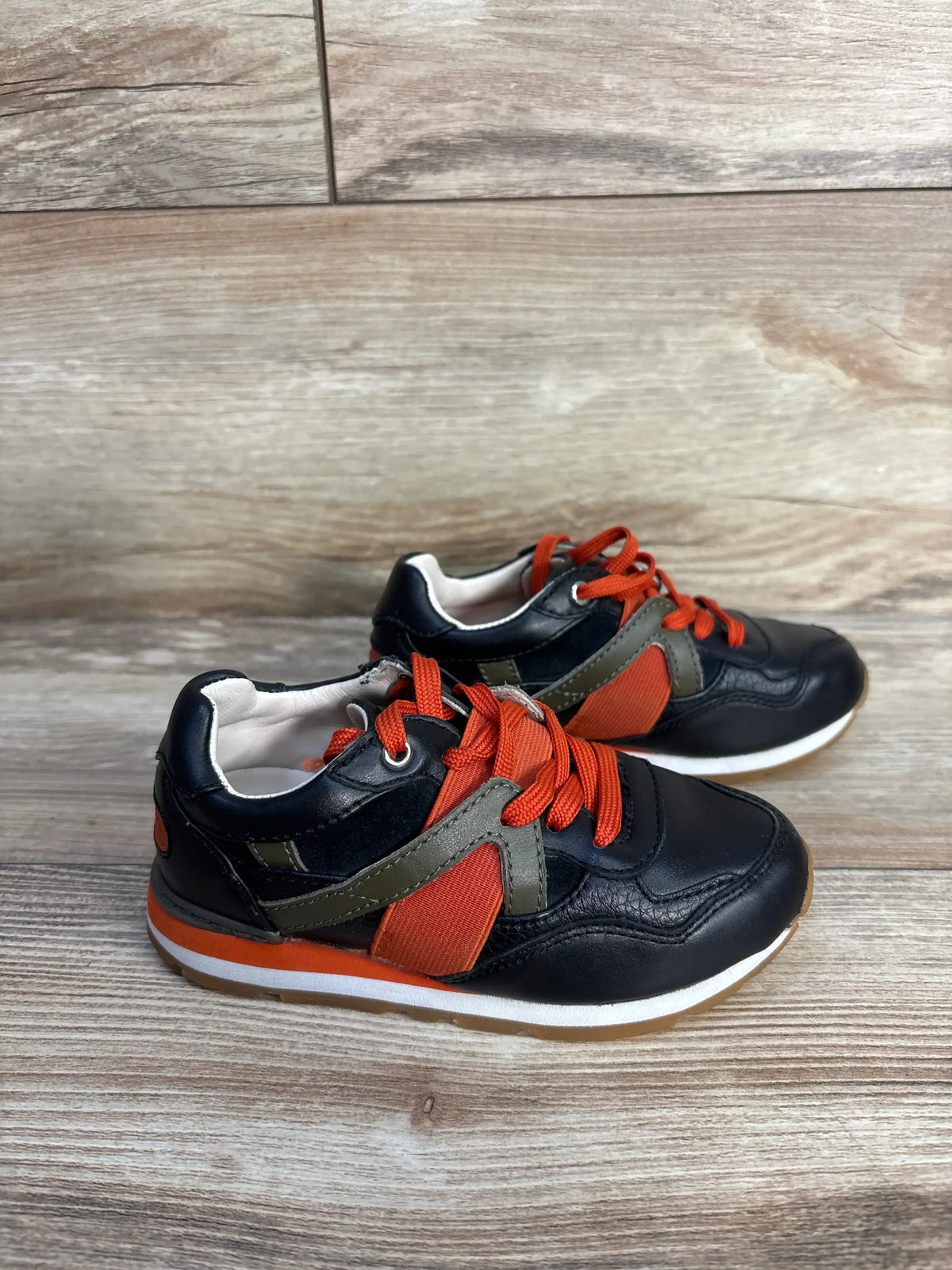 Dolce & Gabbana Bambino leather sneakers in black and orange on a wooden surface