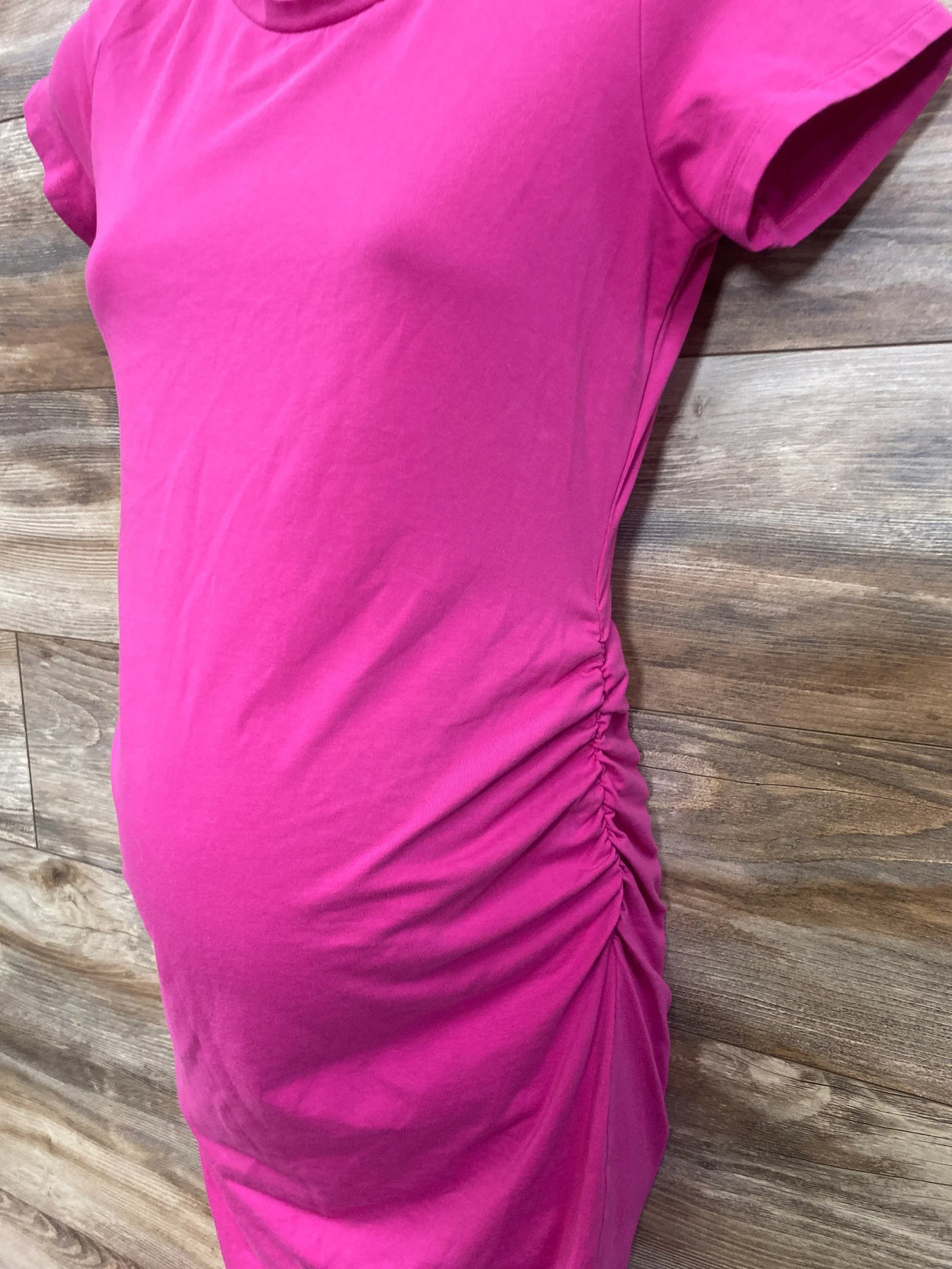 Bright pink maternity dress with ruched side detail, perfect for pregnancy fashion and comfort.