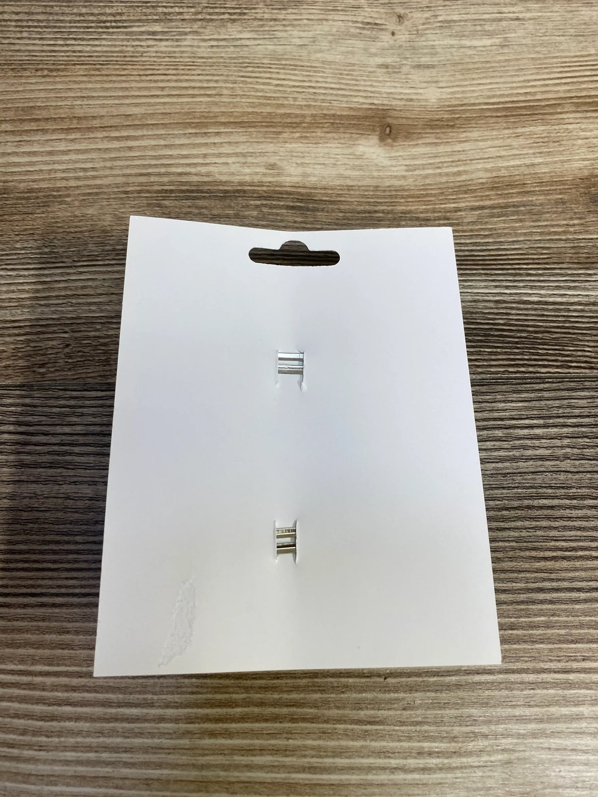 White card with metal clips on wooden surface