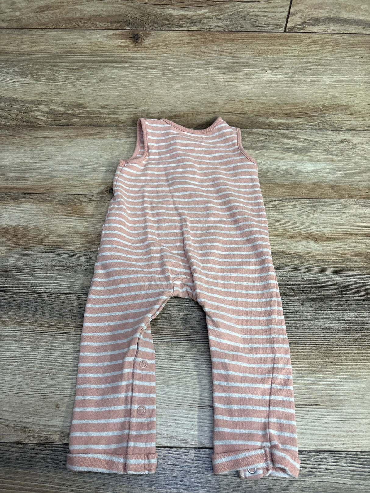 Pink and white striped sleeveless baby romper on wooden floor at kids resale store