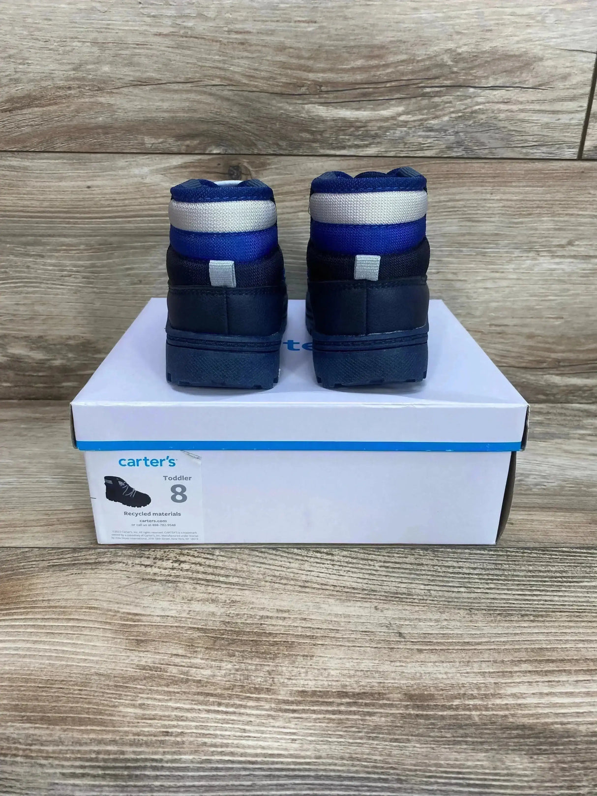 Back view of Carter’s toddler Fallon boots size 8 showing blue-gray padded ankle cuffs and dark soles on a shoebox