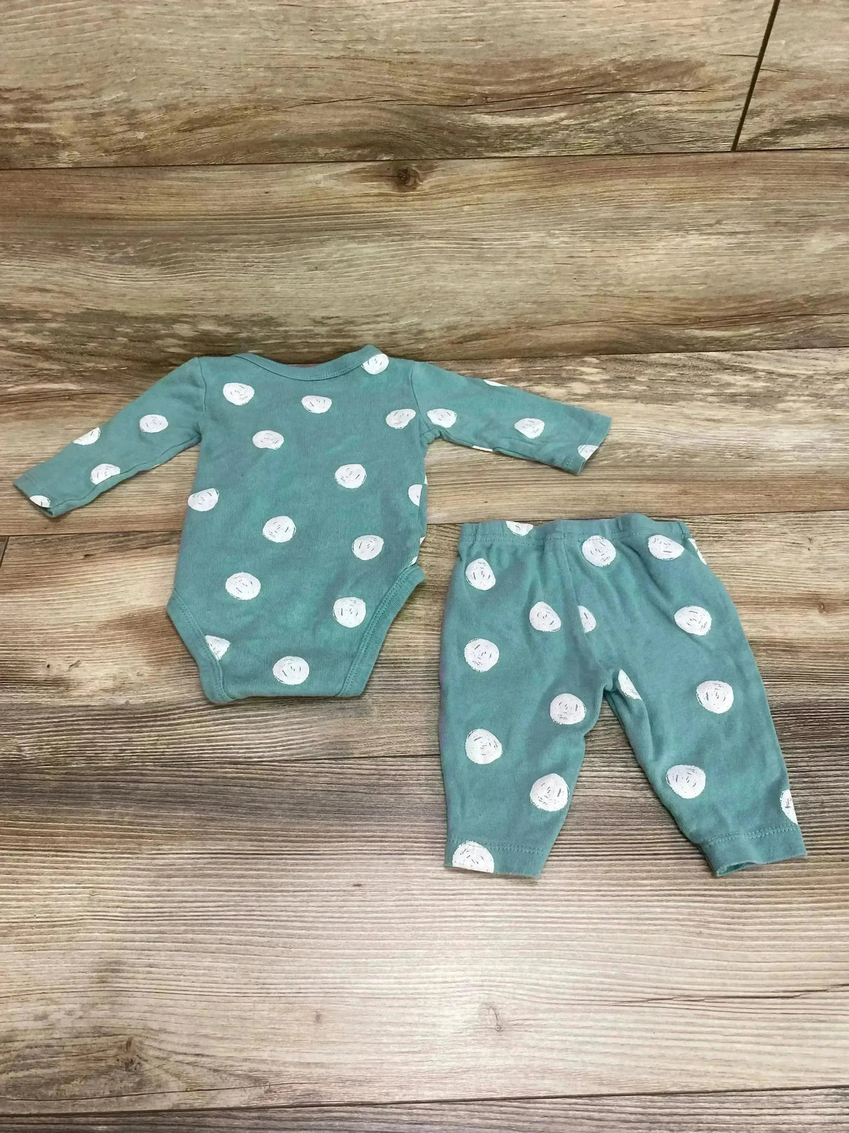 Flat lay of 2-piece kimono bodysuit and pants, green with white circle print, long sleeves, size 3M on wood background