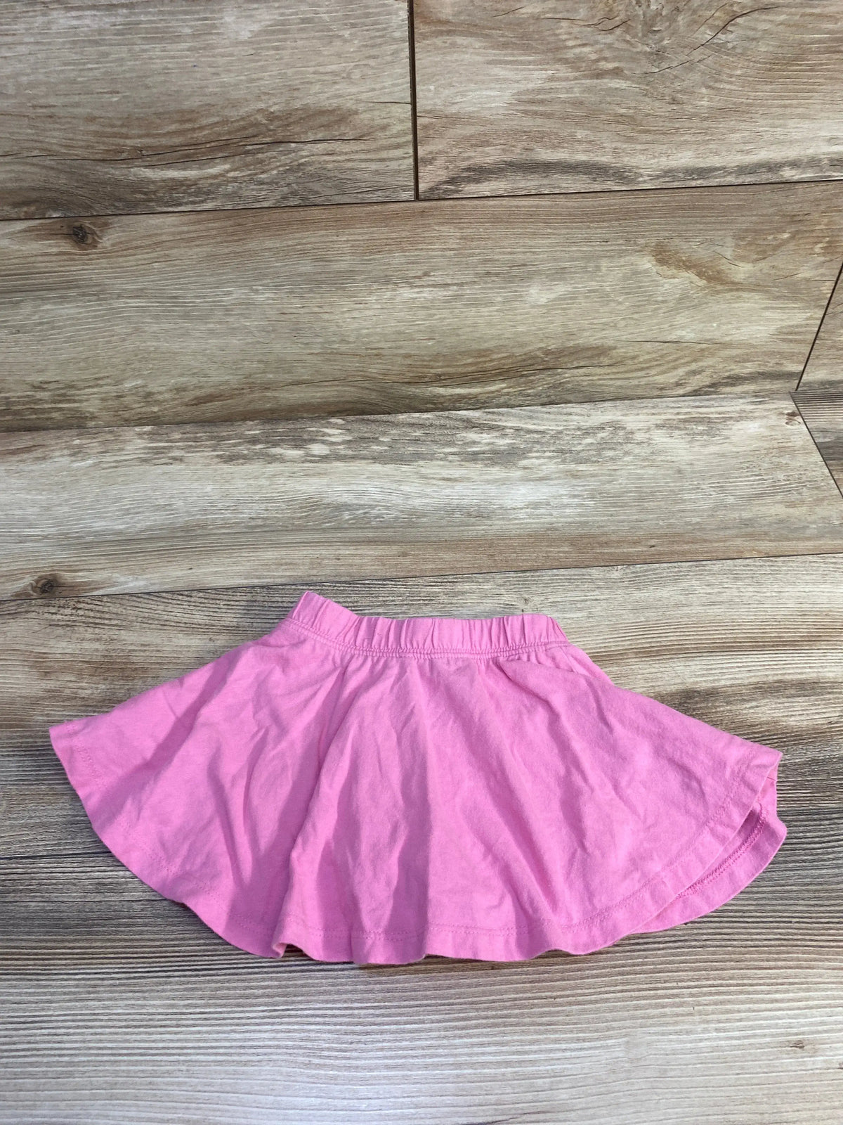 Baby Gap pink pull-on skort for babies size 12-18m on a light brown wooden floor