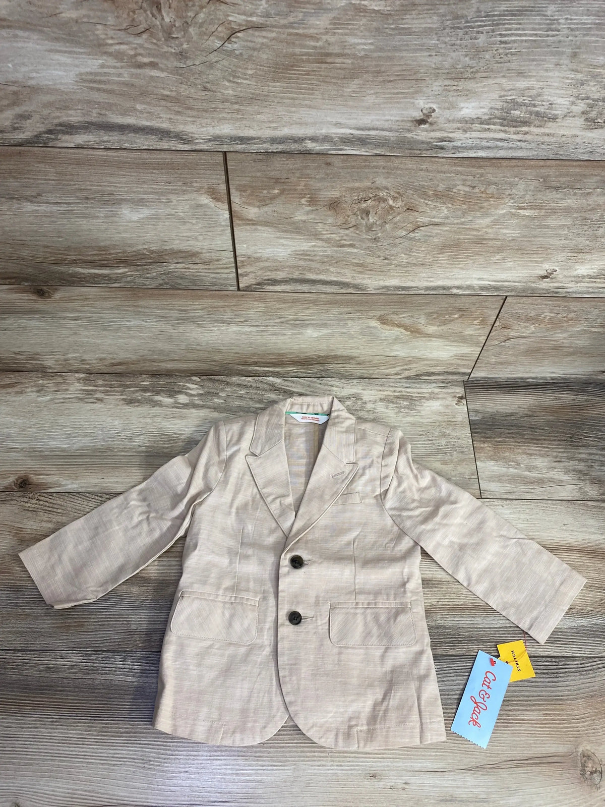 Cat & Jack toddler beige blazer with two buttons and front pockets on wood floor