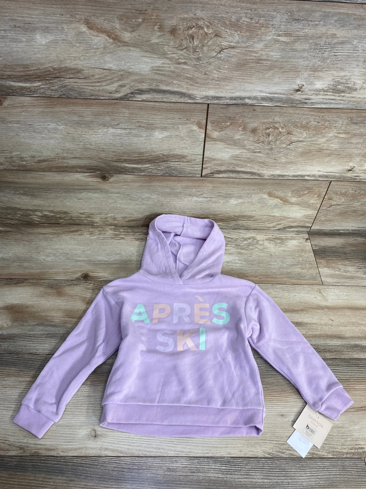 Lavender kids hoodie with 'APRÈS SKI' text, size 6, displayed on wooden floor