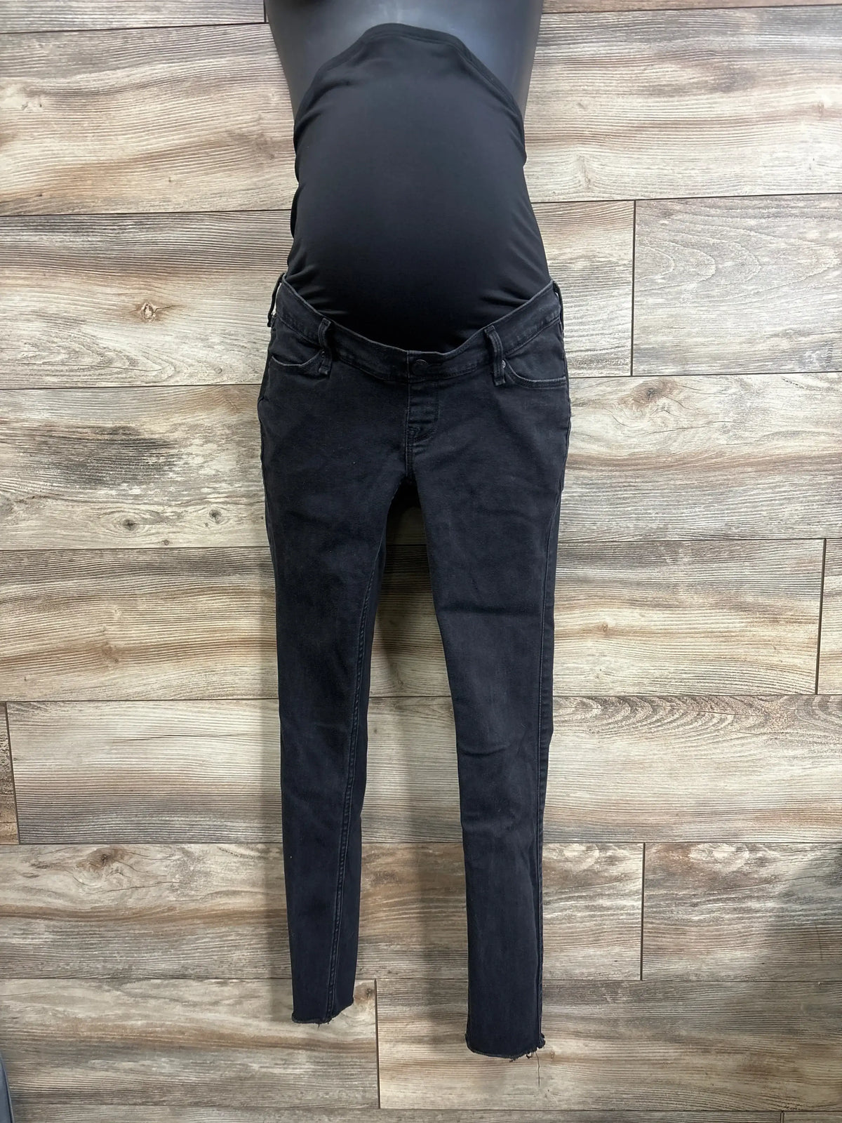 Front view of black maternity jeans leggings showcasing over-belly stretch panel and skinny fit against wood plank background