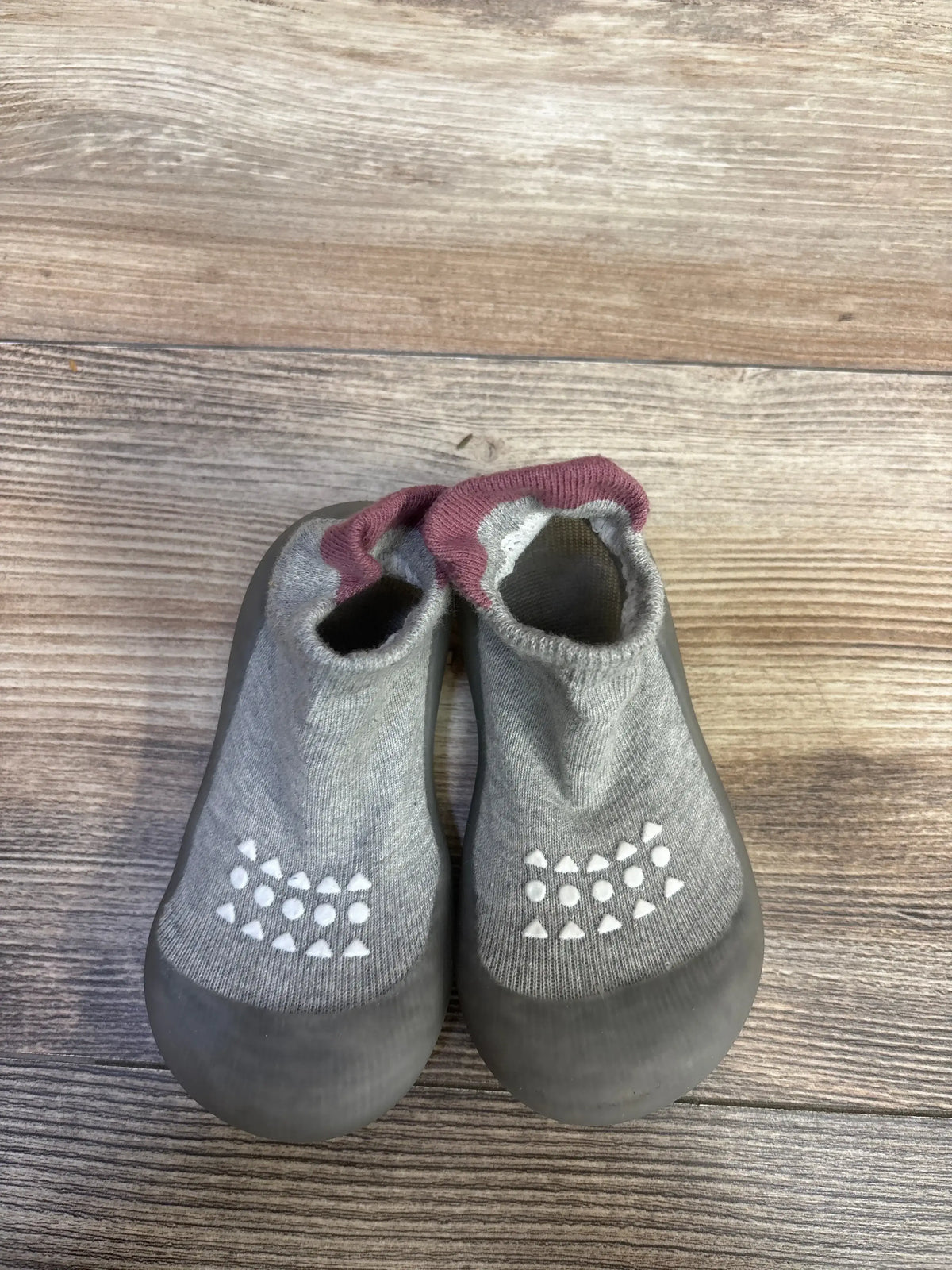 Top view of Bearbay grey infant sock shoes size 7/8C showing rubber toe caps and white non slip grip dots on wooden floor
