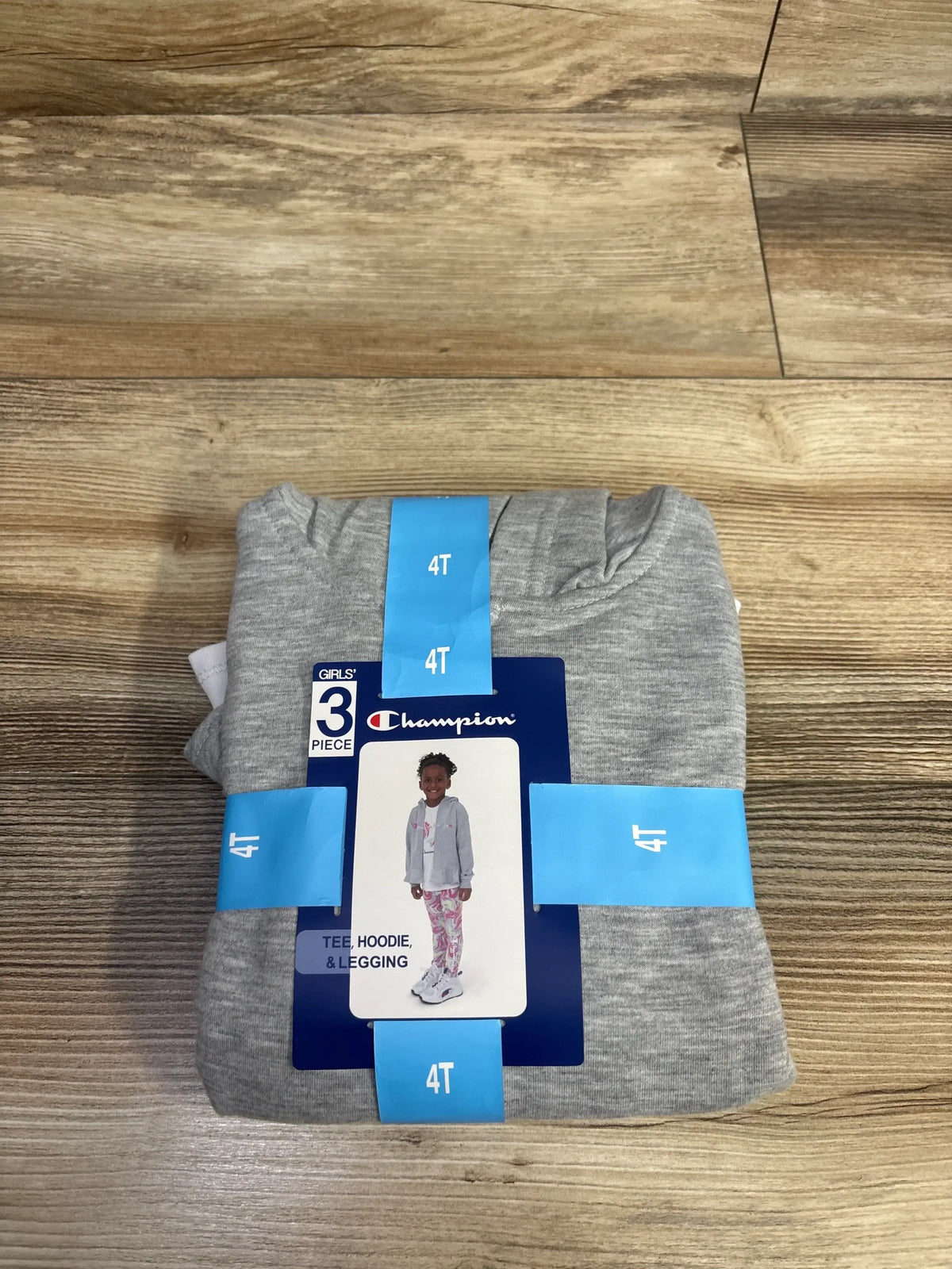 Girls' 3-piece set size 4T with tee, hoodie, and leggings, Champion brand, on wood floor