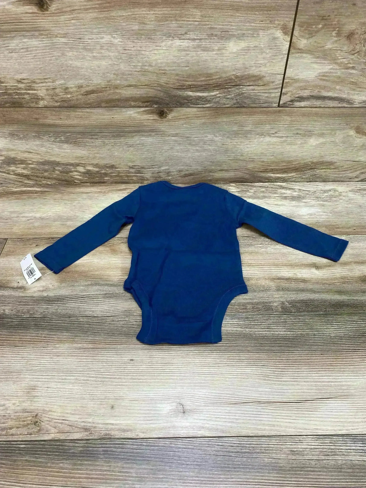 Flat lay of Old Navy long-sleeve blue baby bodysuit size 12-18 months showing back view with tag on wood floor