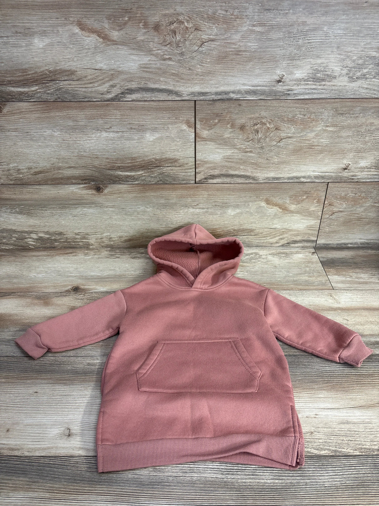 Mauve pink toddler hoodie with kangaroo pocket, displayed on wood background