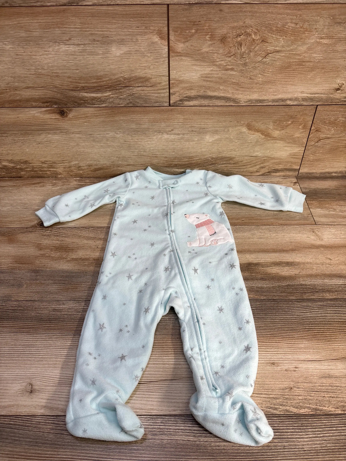 Front view of Carter’s blue blanket sleeper showcasing star pattern, footed legs, front zipper, and dog applique on a wood floor