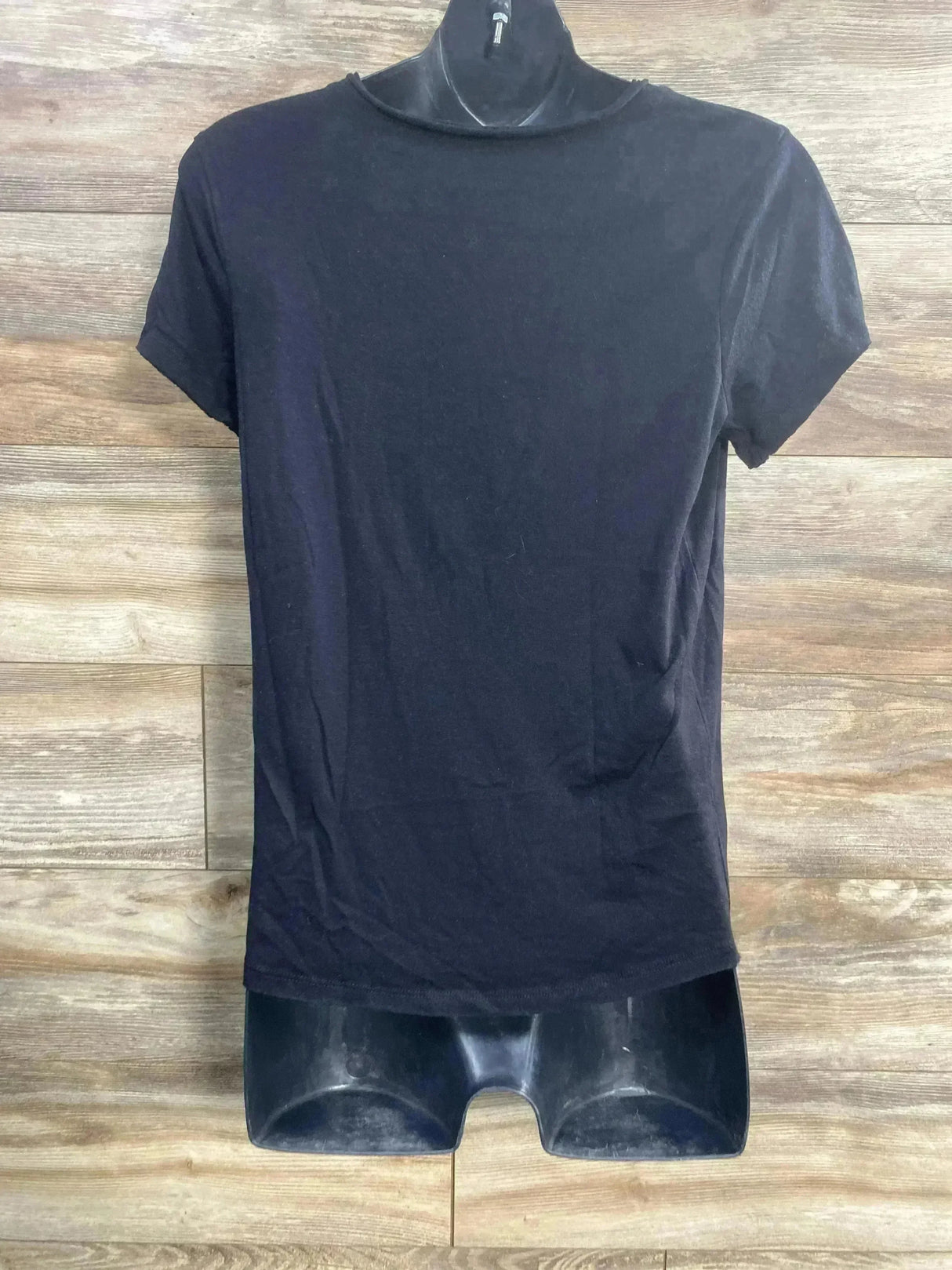 Front of Isabel maternity black short-sleeve tee size small, mock neckline and fitted shape on mannequin against wood background