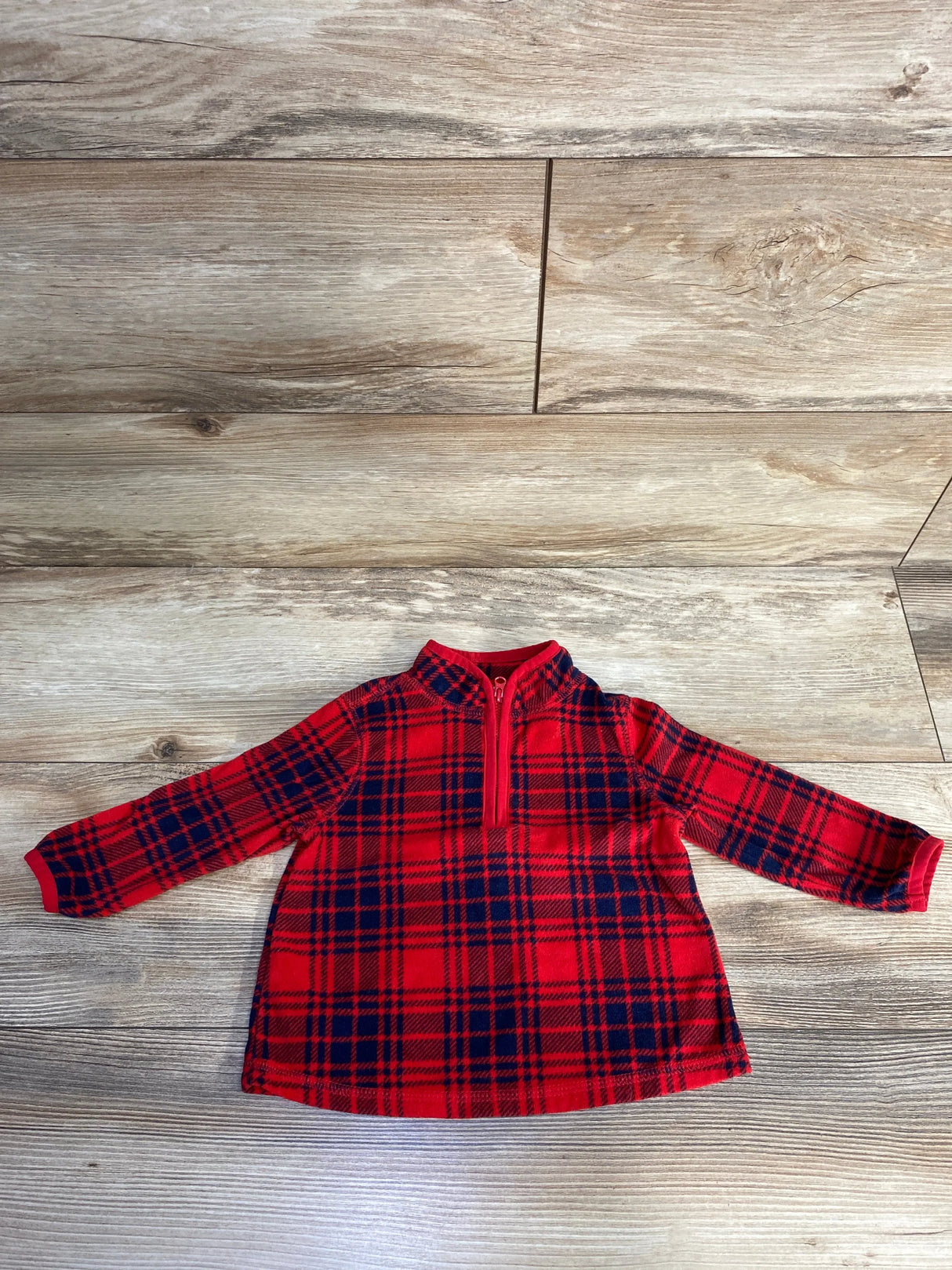 Red plaid long sleeve toddler shirt with front zipper on wood floor