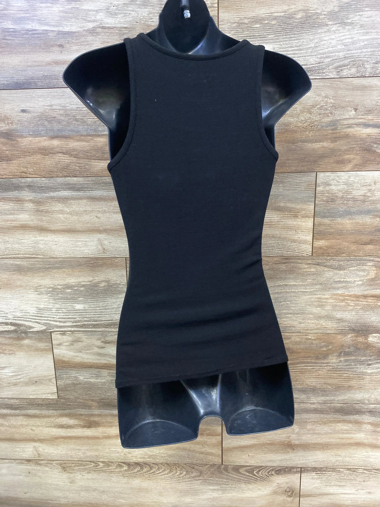 Black ribbed tank top for children displayed on mannequin with wood background