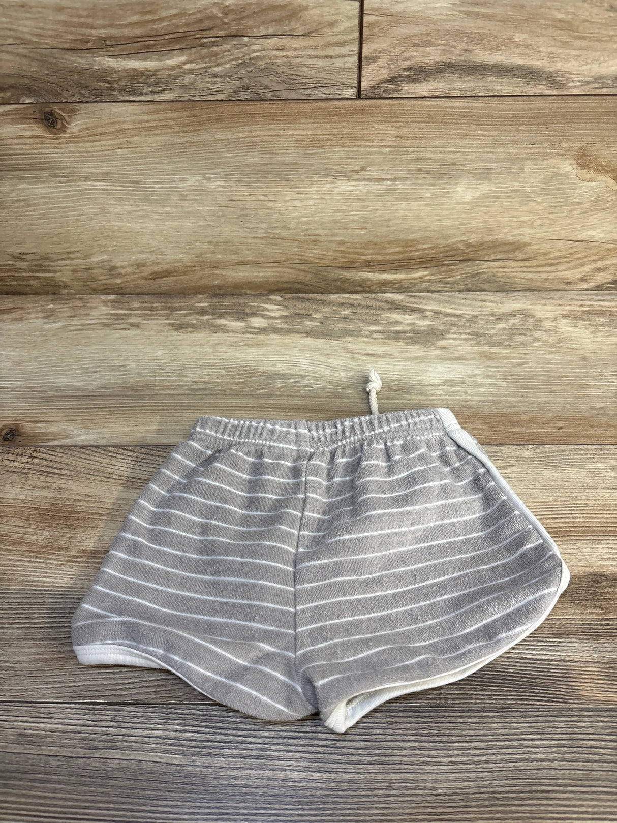 Gray and white striped toddler shorts with drawstring on a wooden background