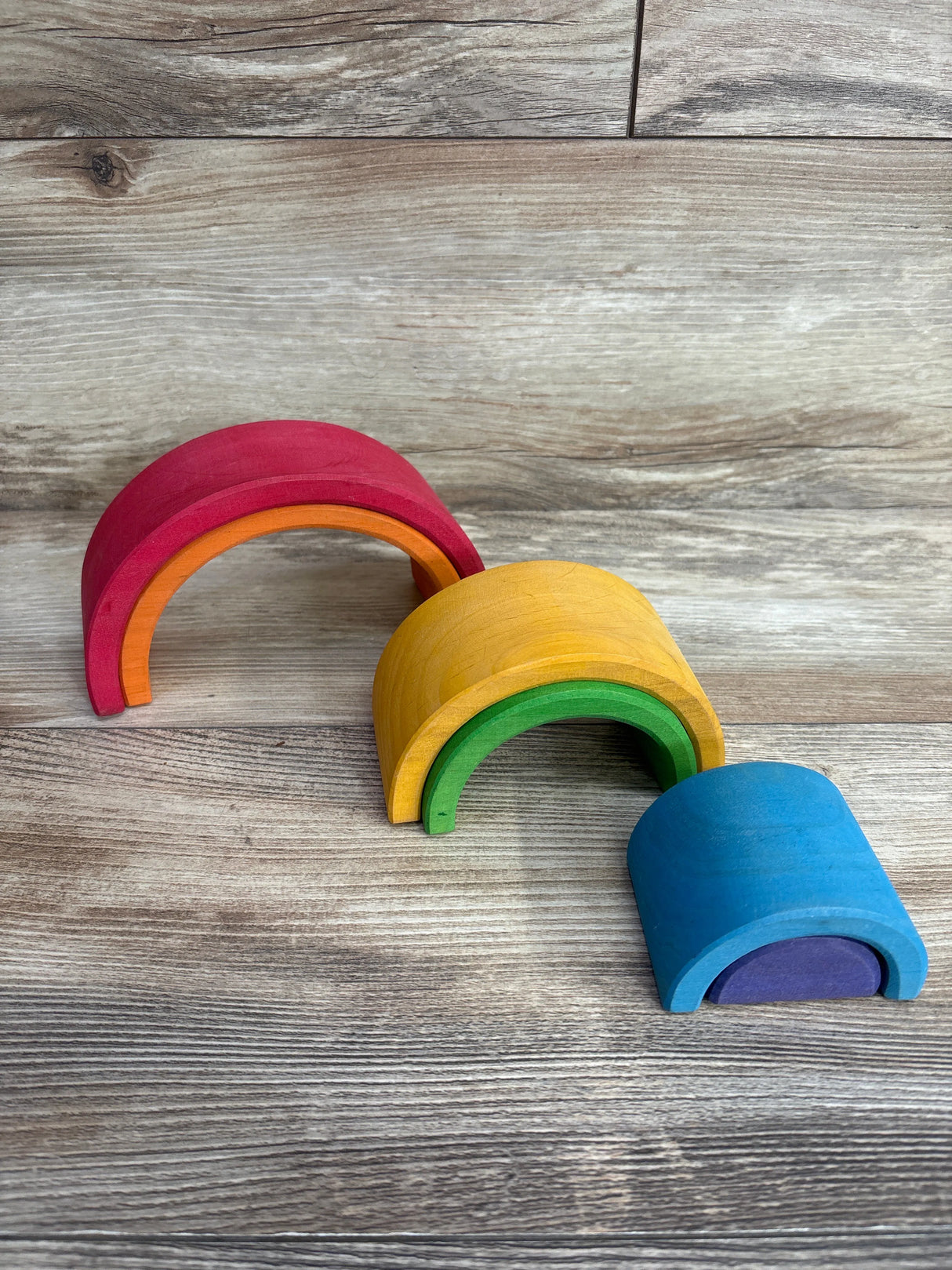 Rainbow stacking wooden toy arches for kids on wood background