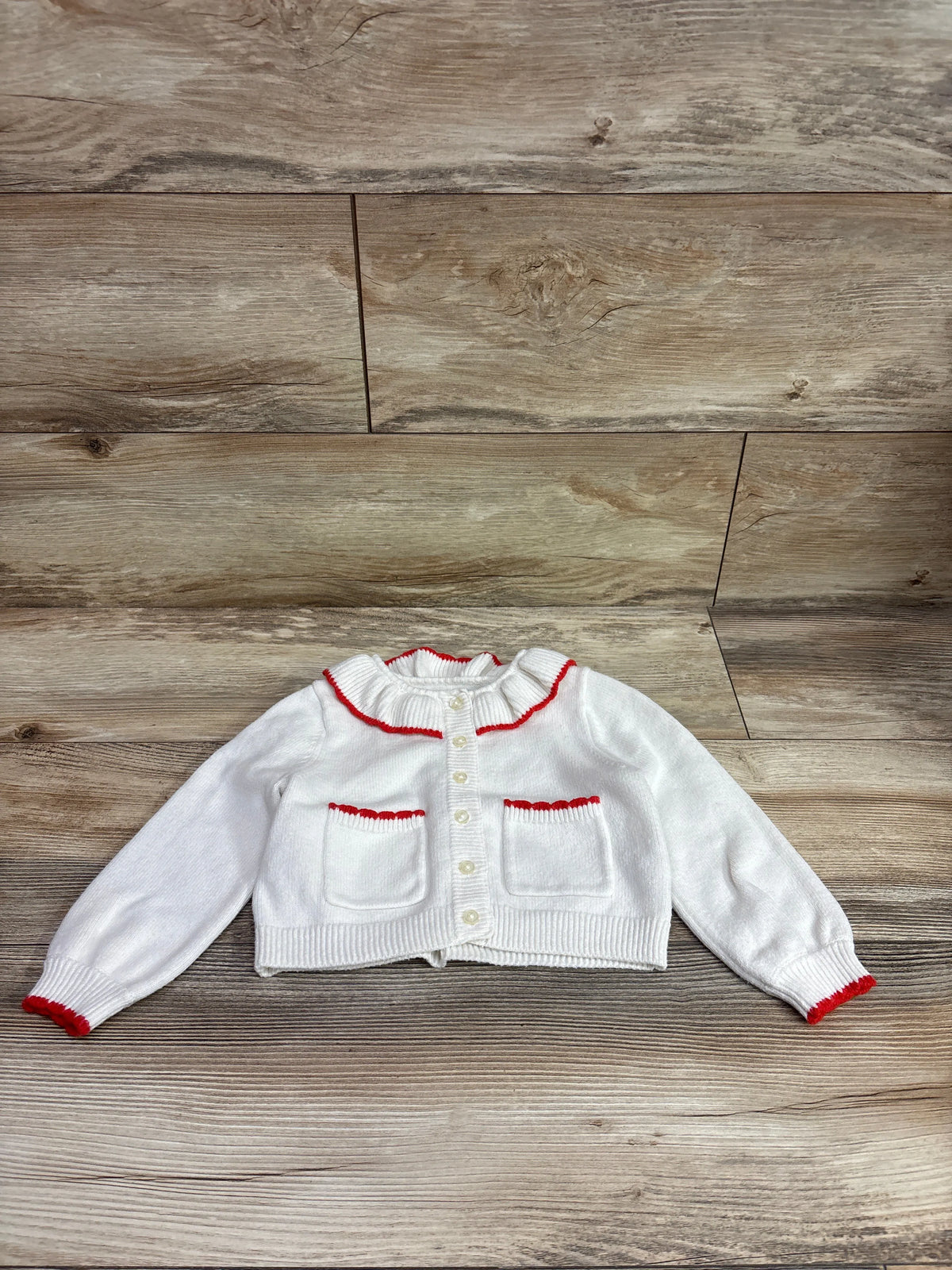 Front view of white knit Amazon Essentials x Sofia Grainge cardigan, size 3T, with red trim and ruffled collar