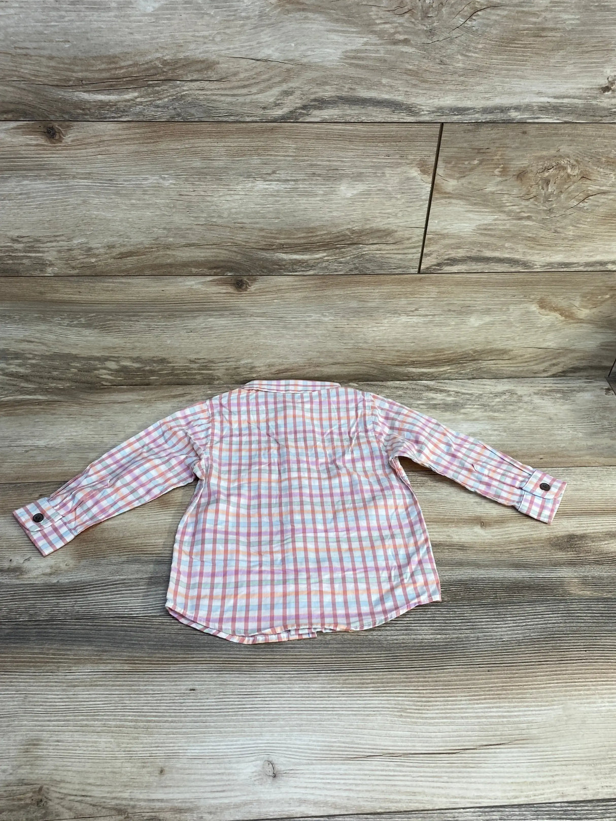 Back view of Cat and Jack plaid long-sleeve button-up shirt in pink and orange checks, size 18 months, laid flat on wood background
