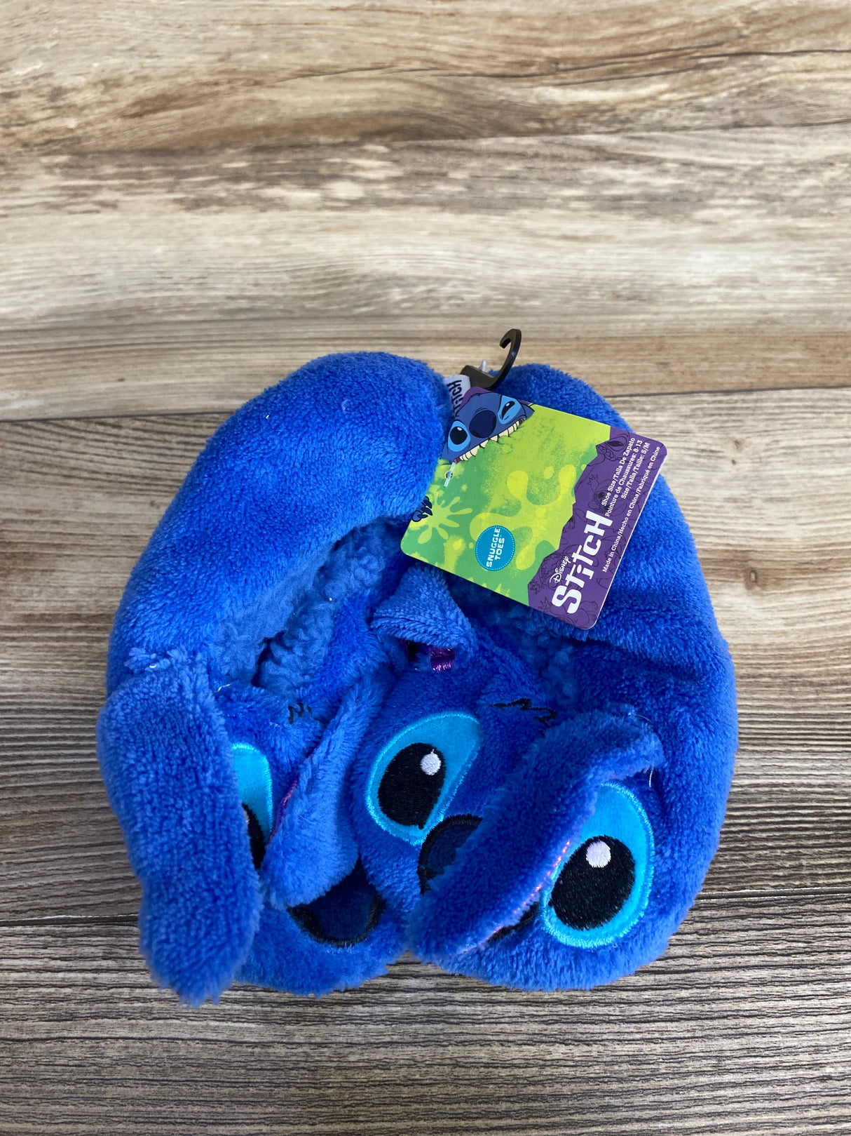 Blue Stitch plush slippers with tag on wood background, Disney Lilo & Stitch merchandise