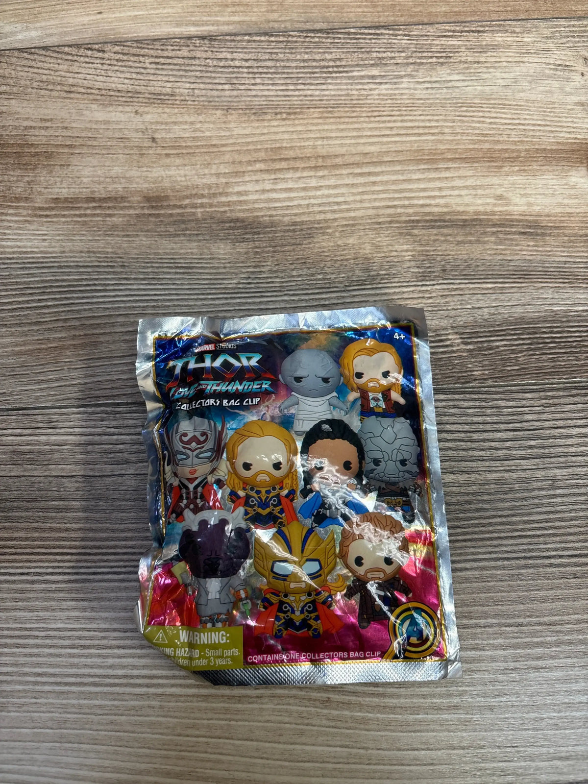 Front view of Marvel Thor: Love and Thunder collectors bag clip showcasing logo and character art on sealed foil packaging with wood background