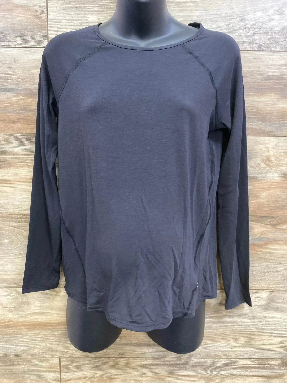 Front view of black Gap maternity long-sleeve shirt size XS showing raglan seams on a mannequin with wood background