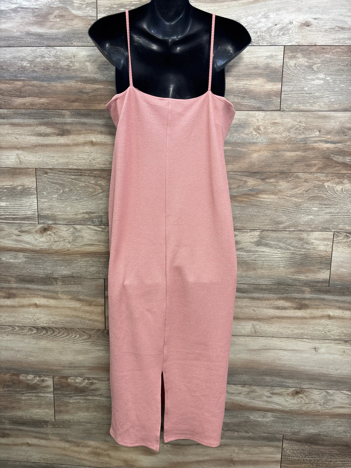Pink textured midi slip dress with spaghetti straps and front slit on mannequin, wooden background