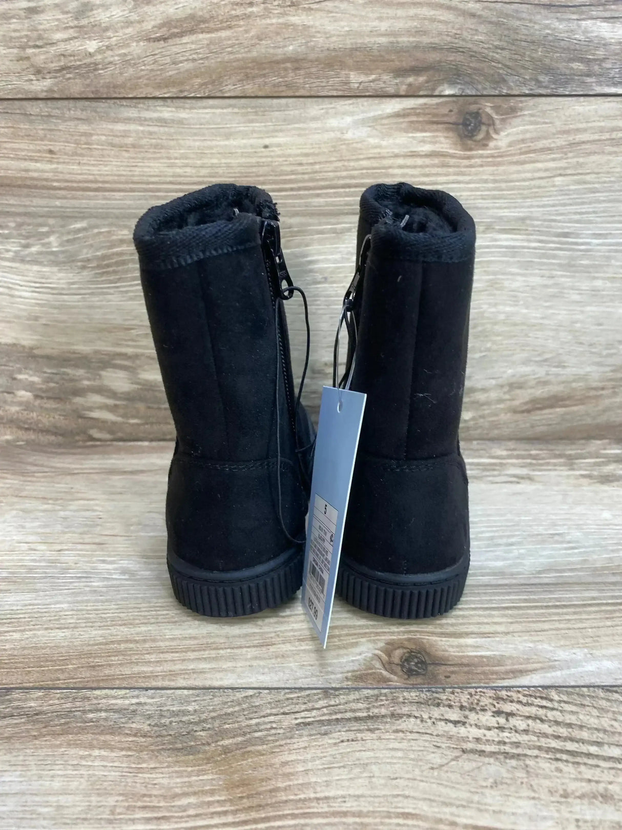 Back view of NEW Cat and Jack Pip shearling style boots in black faux suede showcasing side zipper and hangtag on wood plank floor