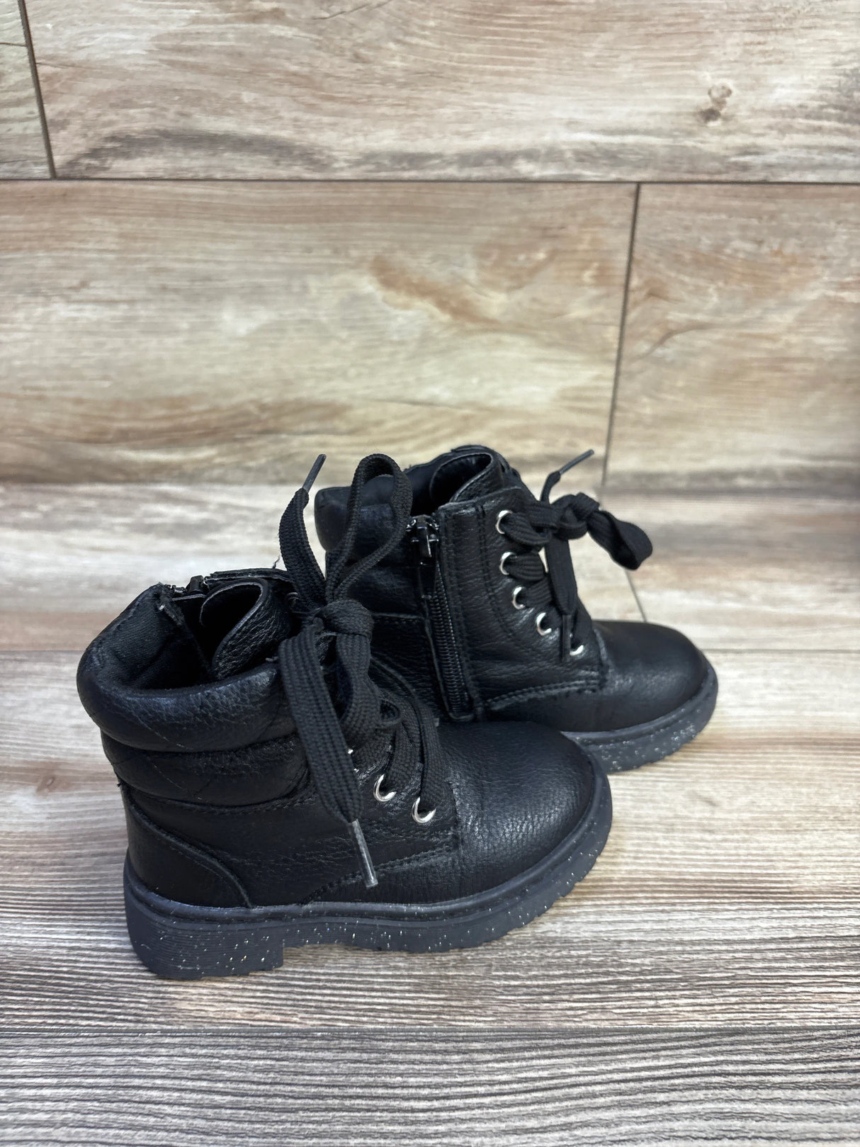 Side view of Sincerely Jules glitter lace-up toddler boots size 7C showing side zipper and speckled sole on wood floor