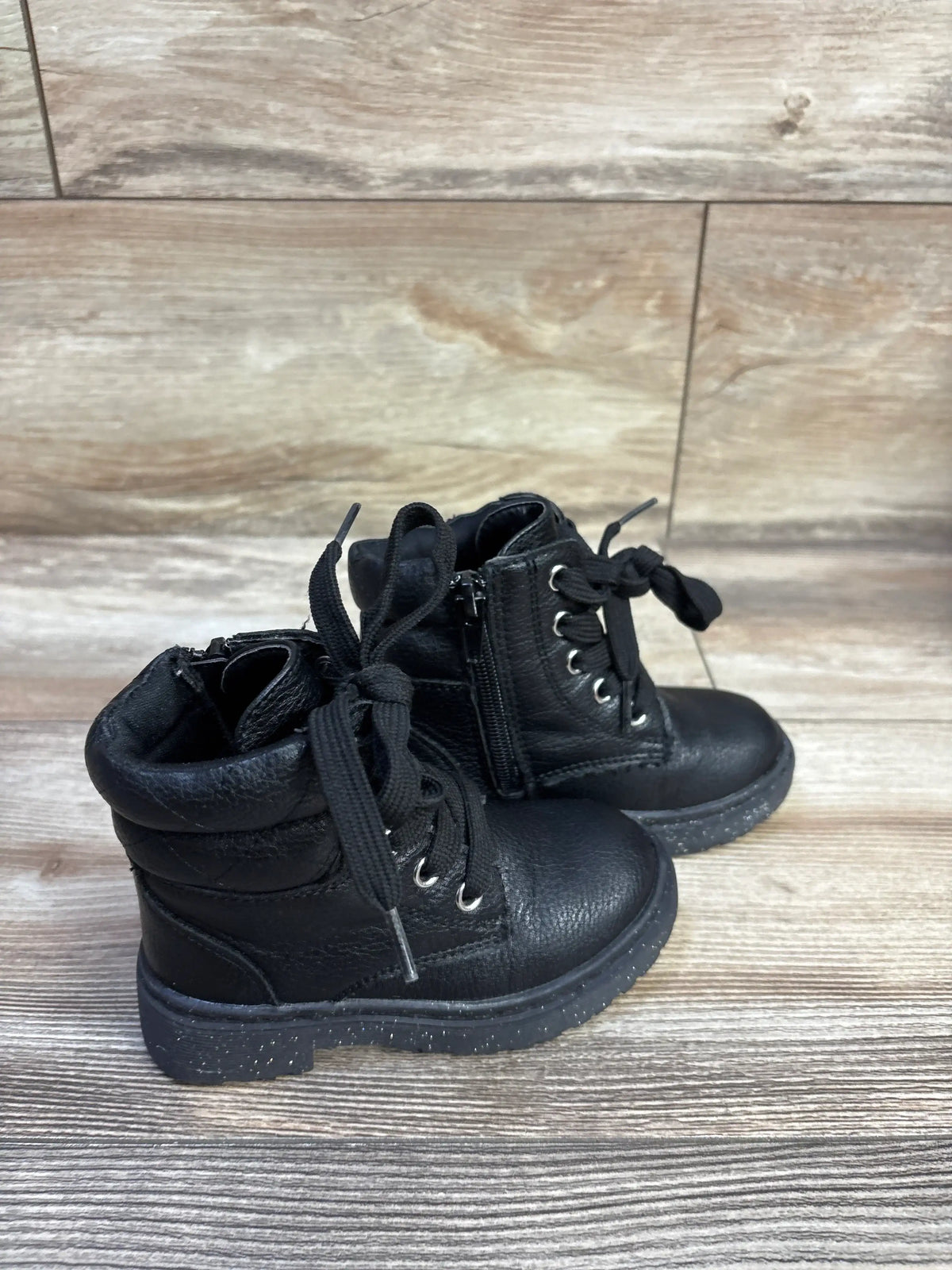 Side view of Sincerely Jules glitter lace-up toddler boots size 7C showing side zipper and speckled sole on wood floor