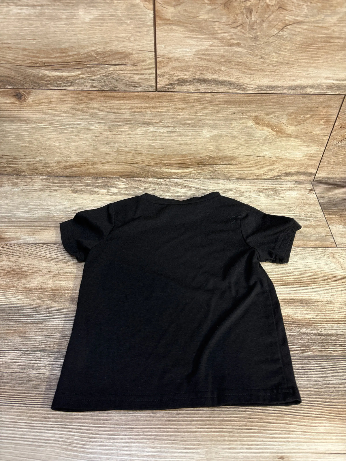 Back view of Shein My Nana and Papa Love Me shirt showcasing short sleeves on a wood floor