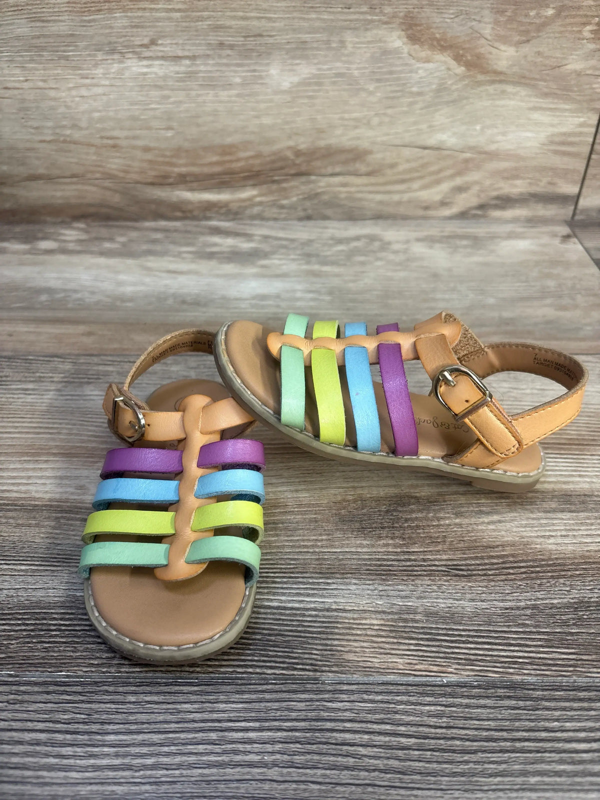 Top view of Cat & Jack Shanel fisherman sandals showcasing multicolored straps and hook and loop closures on a wood surface